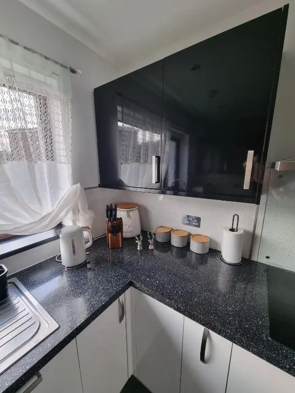 a kitchen with black and white counter top at Highland Breeze Inverness in Inverness