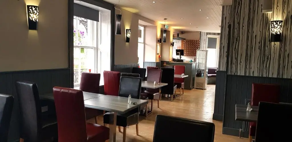 a dining room with tables and chairs in a restaurant at The Havelock in Nairn