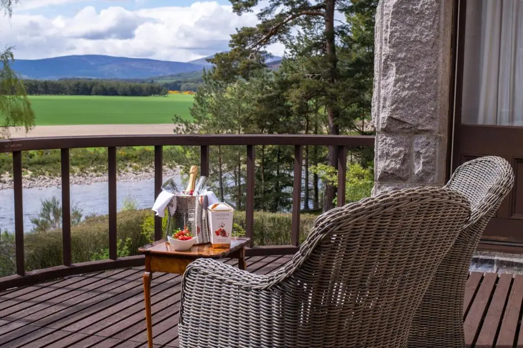 two wicker chairs sitting on a porch with a table at Lys-Na-Greyne Country House in Aboyne