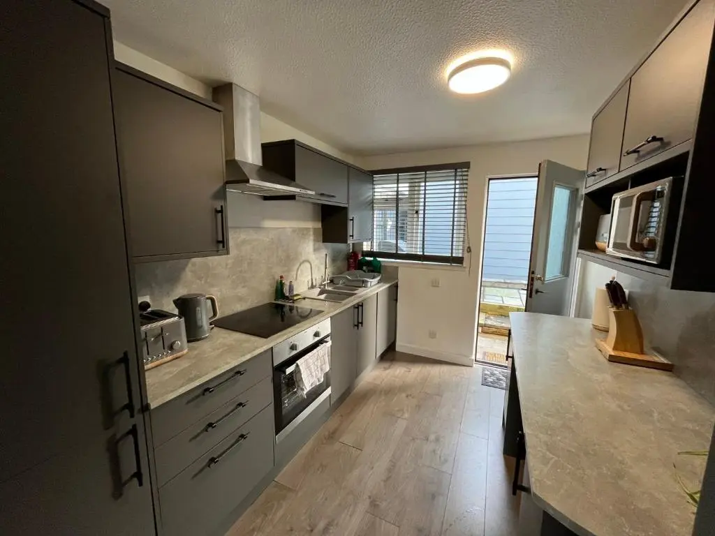 a kitchen with white cabinets and a counter top at 24 Two bedroom apartment Culloden Inverness Highlands in Culloden