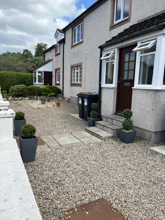 a house with a gravel yard in front of it at 24 Two bedroom apartment Culloden Inverness Highlands in Culloden