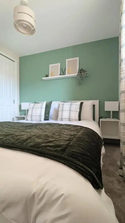 a bedroom with a large bed with a blue wall at The Wee Heilan' Drochaid in Inverness