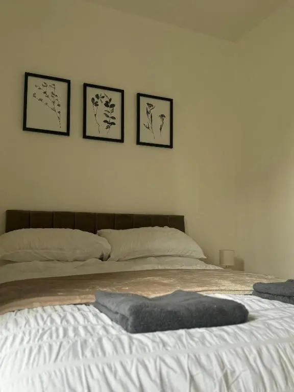 a bedroom with a bed with three pictures on the wall at Stephen's Brae Apartment, Inverness City Centre in Inverness