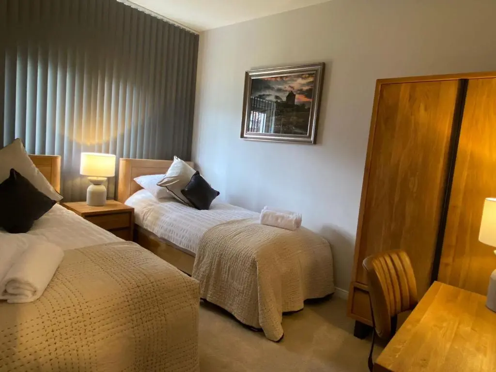 a hotel room with two beds and a table at travelNess Apartment in Inverness