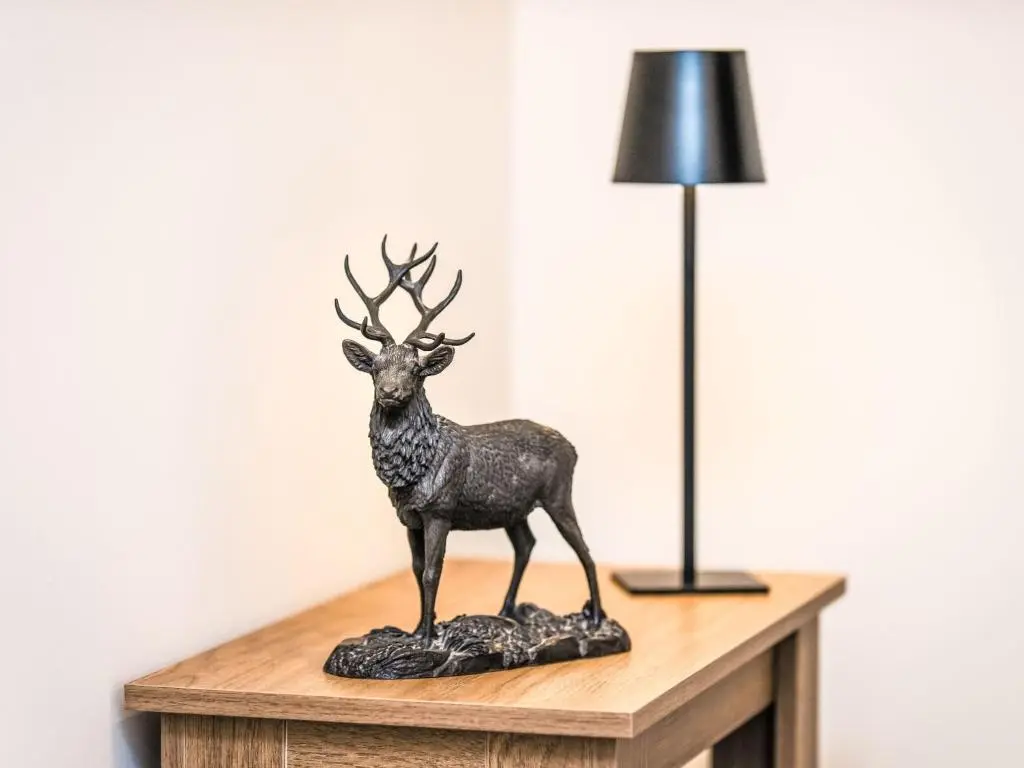 a bronze deer statue sitting on a table next to a lamp at Apartment Varis Haven by Interhome in Forres