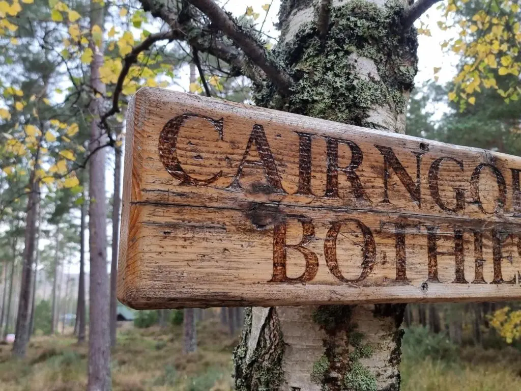 a sign attached to a tree in a forest at Apartment Ghillie's Bothy by Interhome in Coldstone