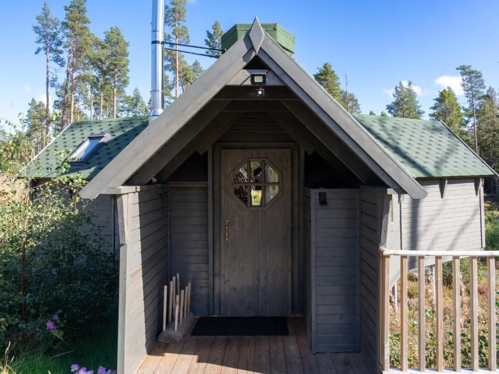 a wooden outhouse with a door on a deck at Apartment Ghillie's Bothy by Interhome in Coldstone