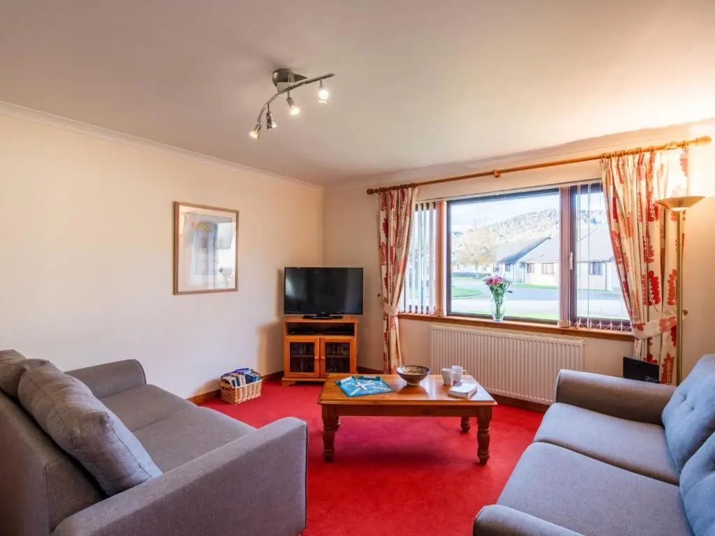 a living room with two couches and a tv at Holiday Home Coiltie House by Interhome in Drumnadrochit