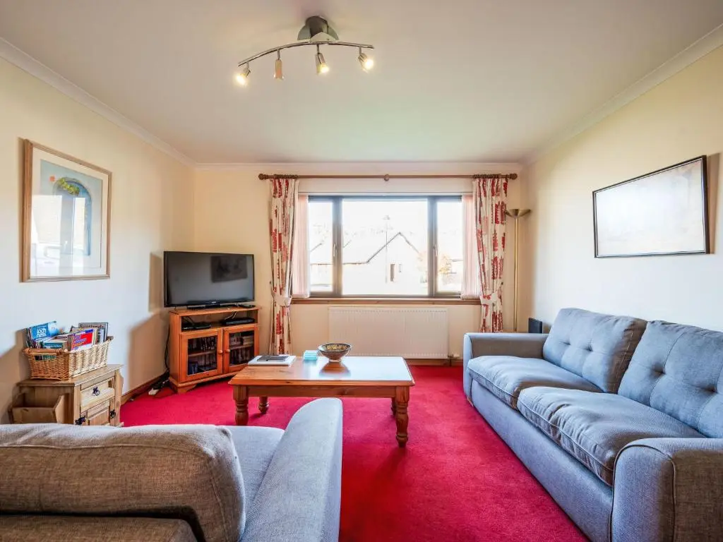 a living room with a couch and a table at Holiday Home Coiltie House by Interhome in Drumnadrochit