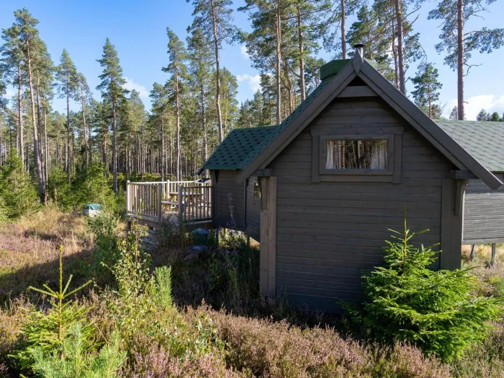 a small house with a deck in the woods at Apartment Birch Bothy by Interhome in Coldstone