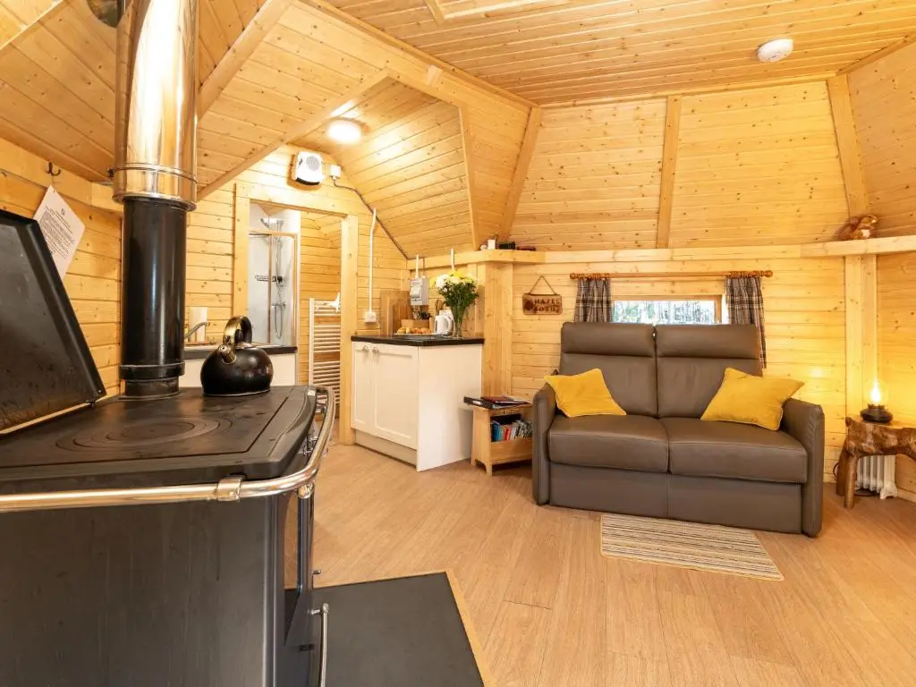 a living room with a couch and a stove at Apartment Hazel Bothy by Interhome in Coldstone