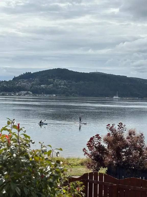two people are rowing in a large body of water at Seaside Retreat - Quiet Seafront Spot with Free Parking in North Kessock