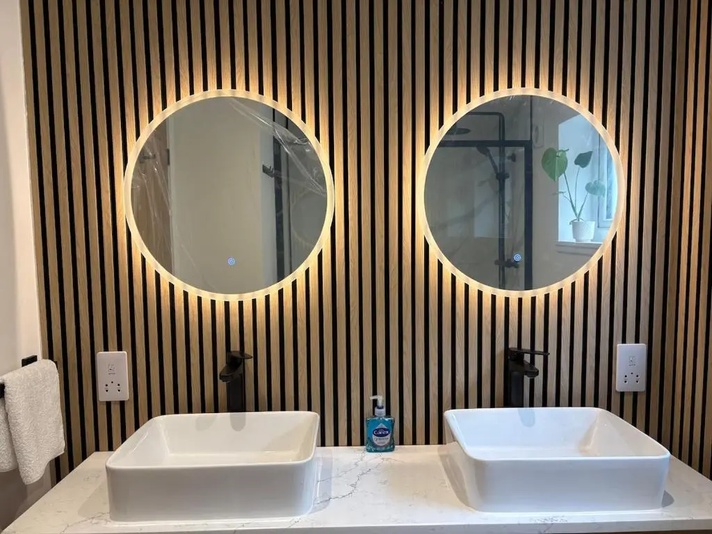 two sinks in a bathroom with two mirrors on the wall at Seaside Retreat - Quiet Seafront Spot with Free Parking in North Kessock