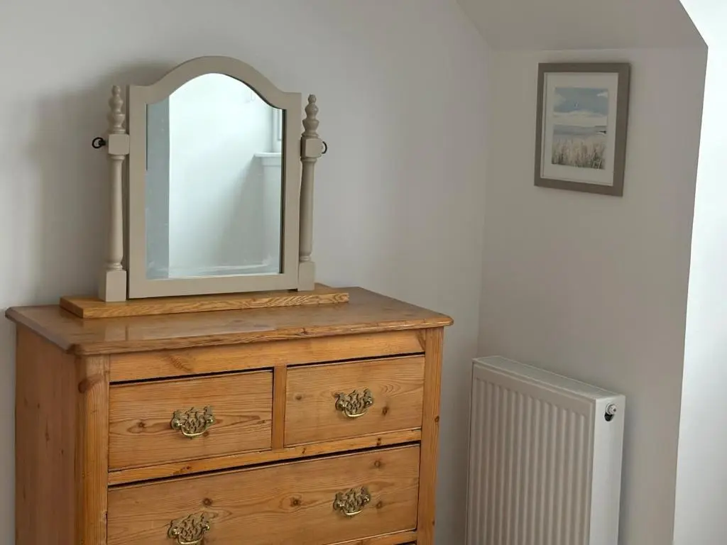 a dresser with a mirror on top of it at Seaside Retreat - Quiet Seafront Spot with Free Parking in North Kessock