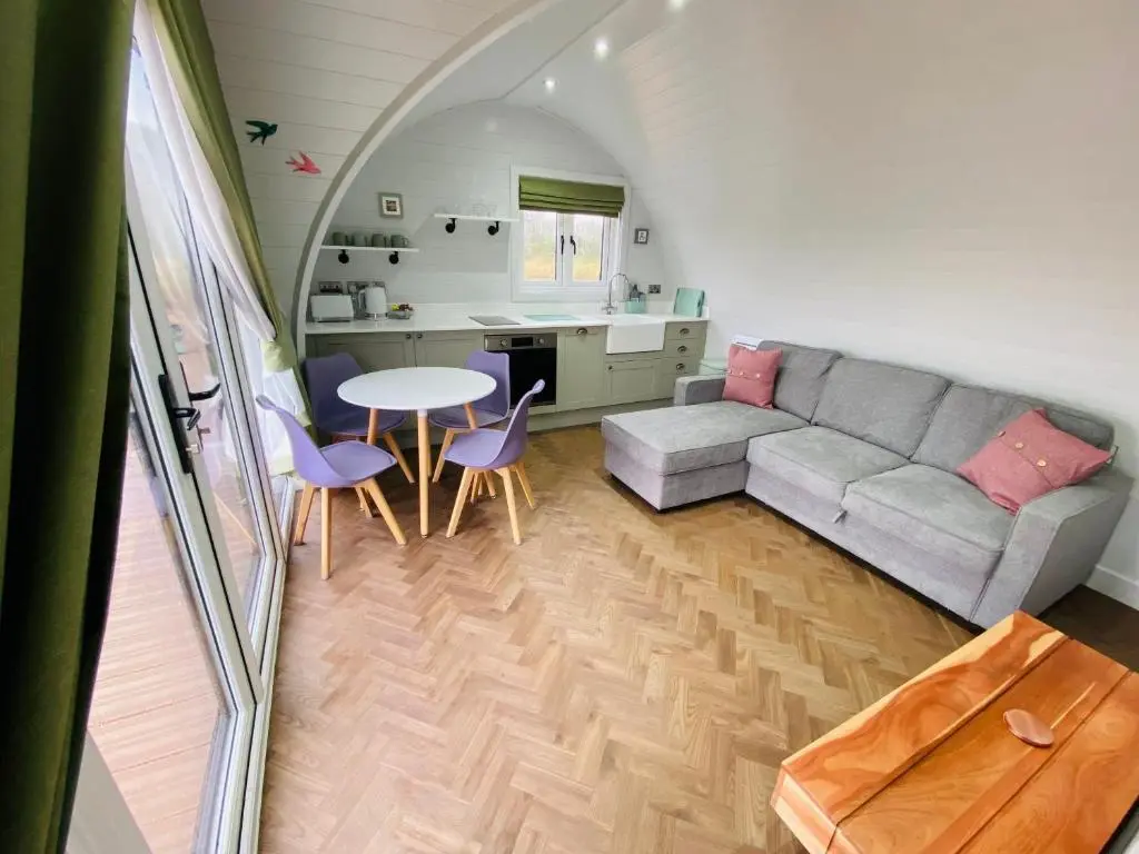 a living room with a couch and a table at Dornoch Pods in Dornoch