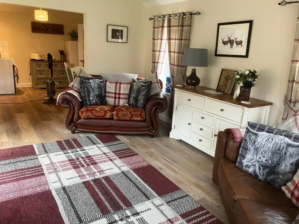 a living room with a couch and a rug at Struan Cottage in Ballater