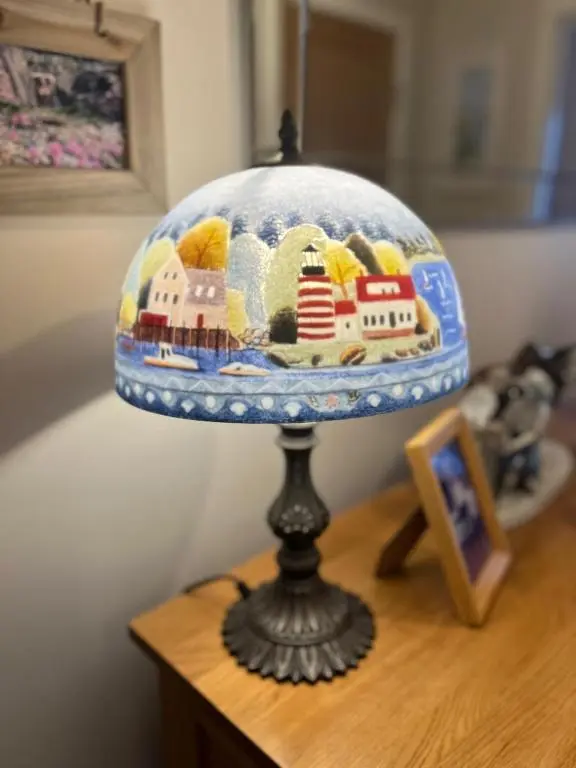 a lamp on a wooden table with a plate ofiture at Lighthouse Cottage Cullen in Cullen