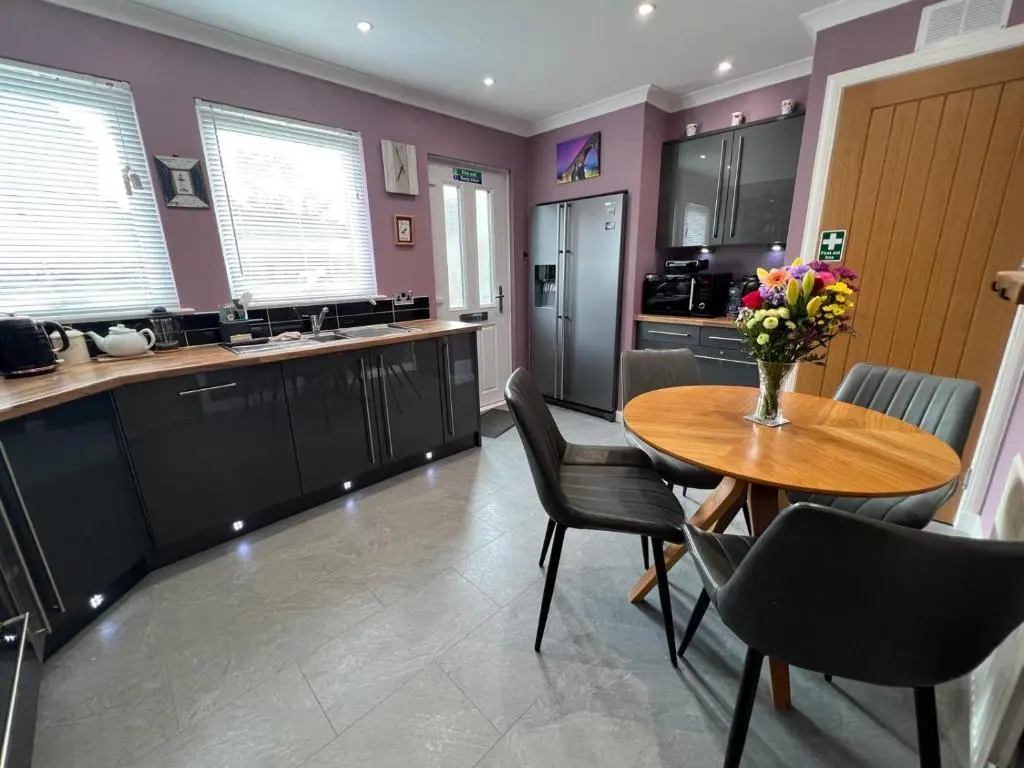 a kitchen with a wooden table and black chairs at Lighthouse Cottage Cullen in Cullen
