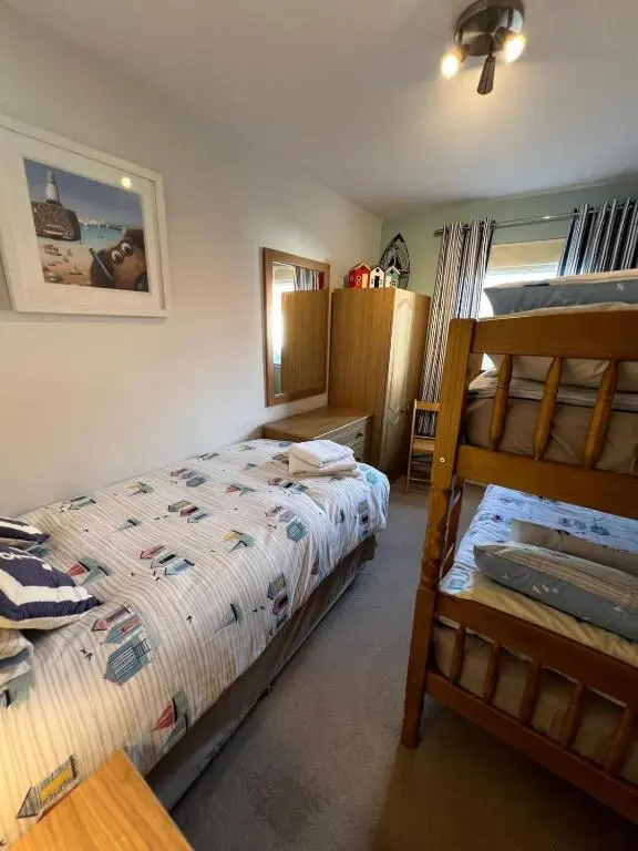 a bedroom with two beds and a bunk bed at Lighthouse Cottage Cullen in Cullen