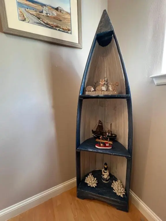 a wooden shelf with a toy in the corner of a room at Lighthouse Cottage Cullen in Cullen