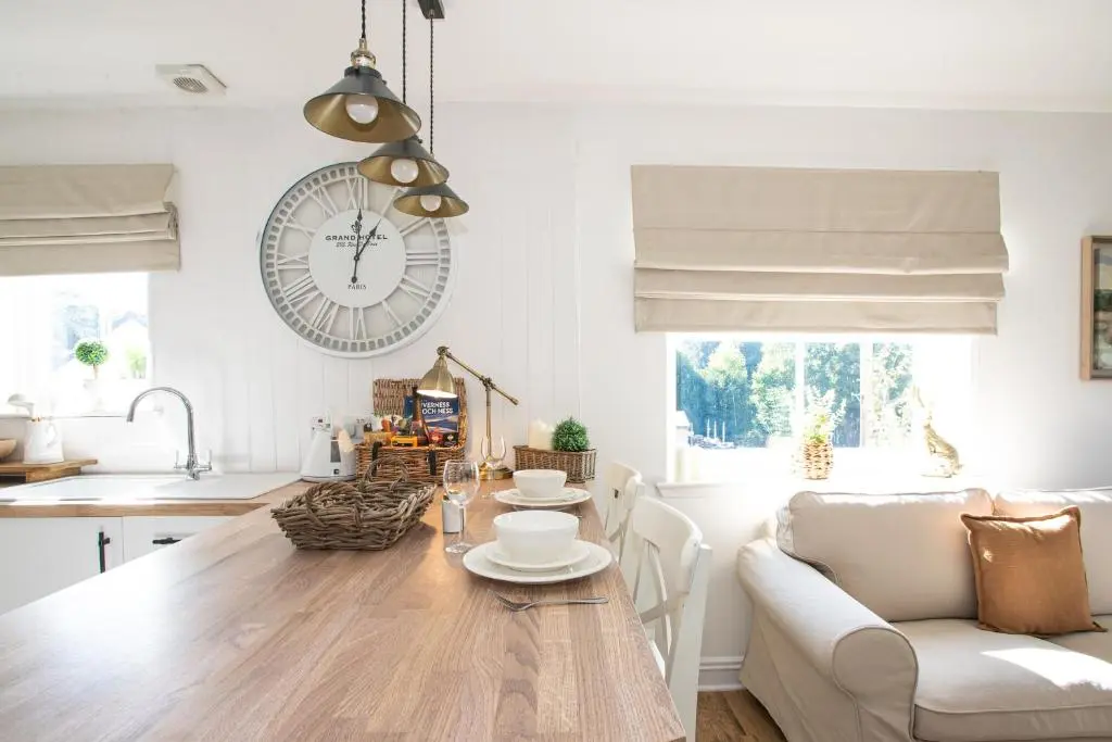 a kitchen and living room with a table and a clock at Lillymont Apartment - Inverness City Centre in Inverness