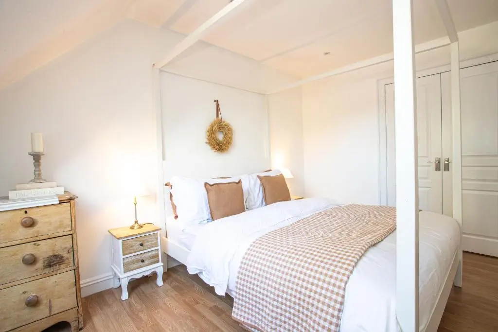 a white bedroom with a bed and a dresser at Lillymont Apartment - Inverness City Centre in Inverness