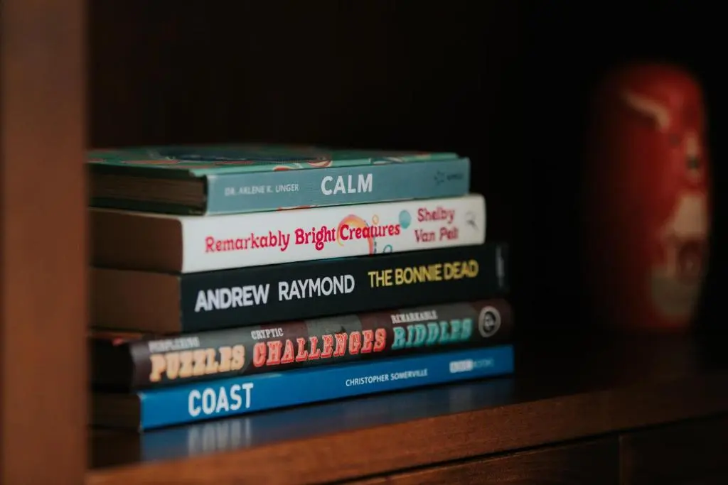 a stack of books sitting on a shelf at Spacious Flat with Parking Great Inverness Base in Inverness