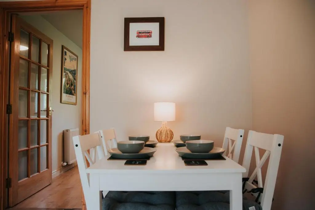 a white table with chairs and a lamp on it at Spacious Flat with Parking Great Inverness Base in Inverness