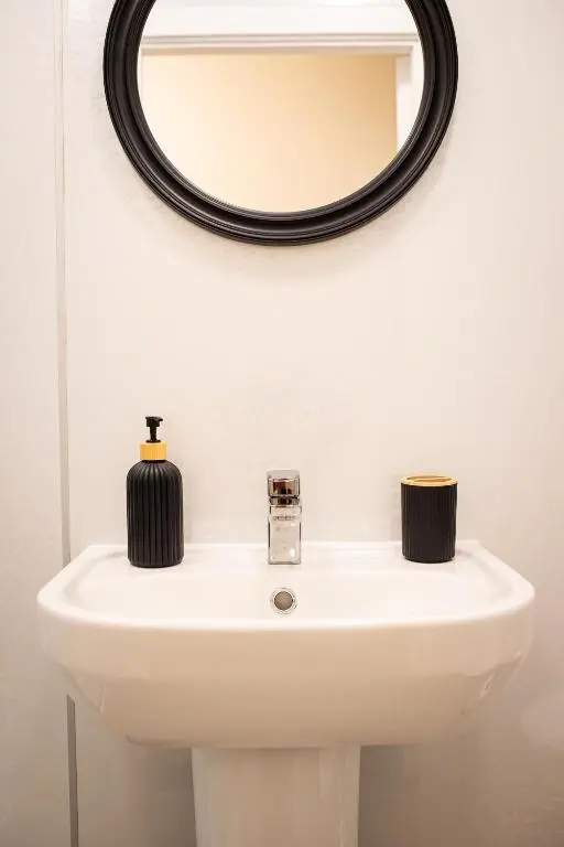 a bathroom with a white sink and a mirror at Baron Taylor Stays in Inverness