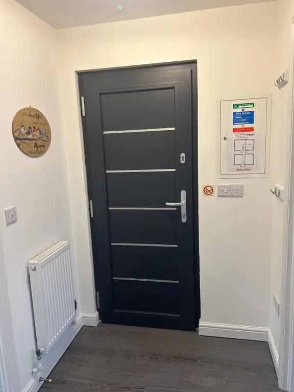 a black door in a room with a radiator at Chloes Holiday Apartments in Inverness