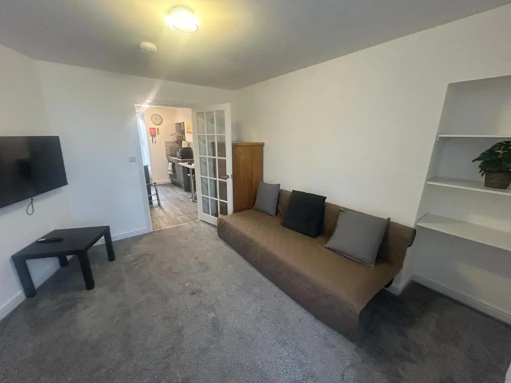a living room with a couch and a tv at Chloes Holiday Apartments in Inverness
