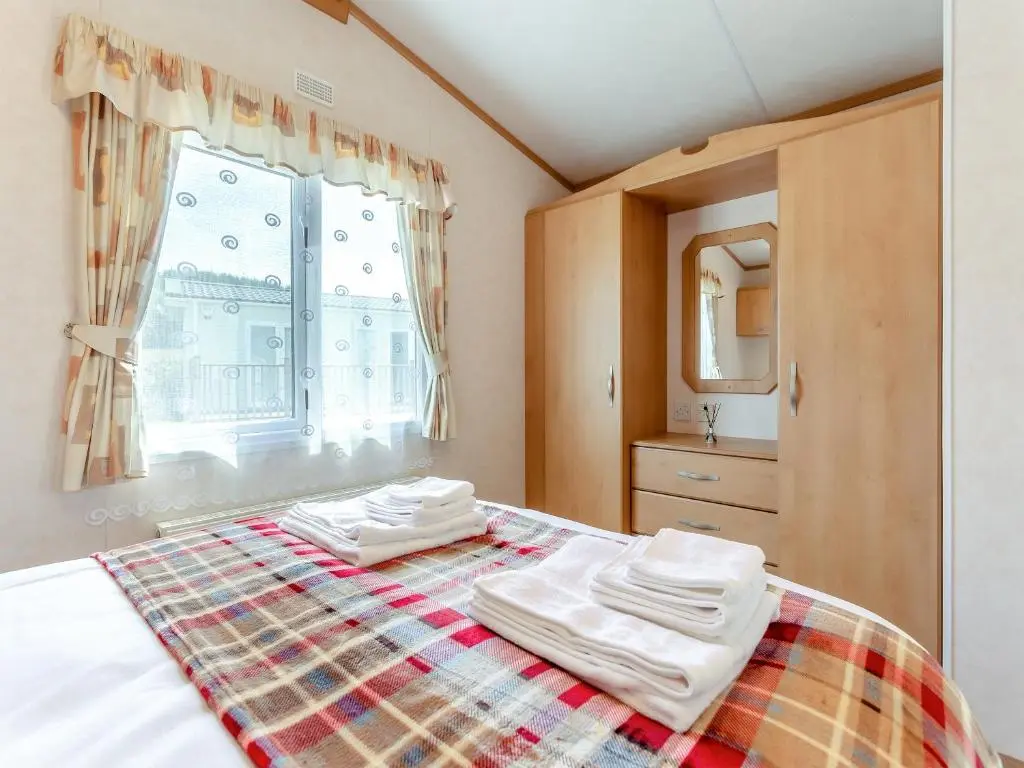 a bedroom with a bed with towels on it at Sunny Firth in Tain
