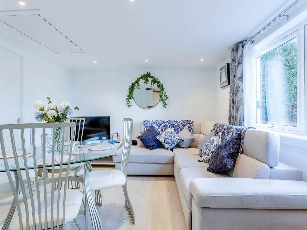 a living room with a white couch and a glass table at Charlies Cottage in Inverness