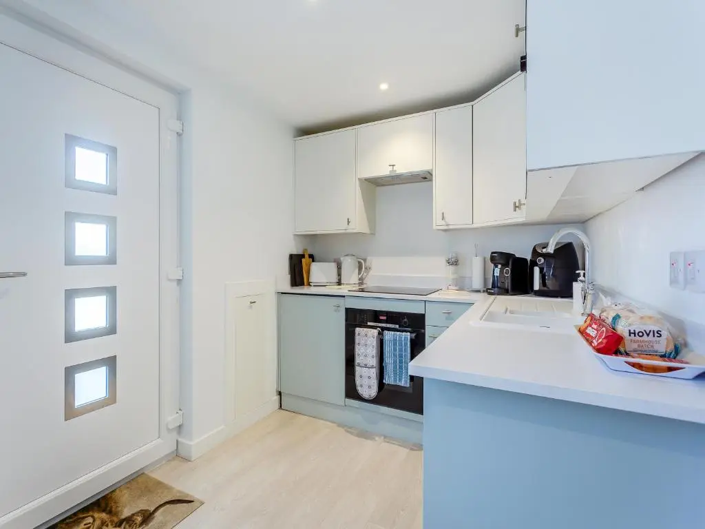 a kitchen with white cabinets and a counter top at Charlies Cottage in Inverness