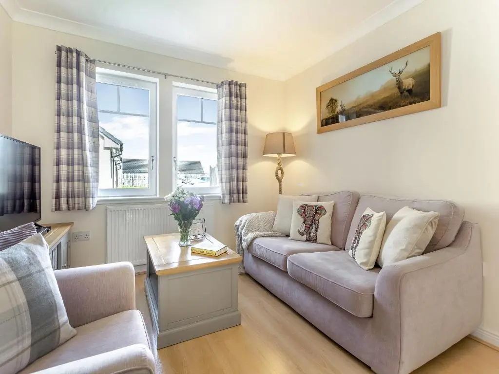 a living room with a couch and a table at Kincraig Apartment in Inverness