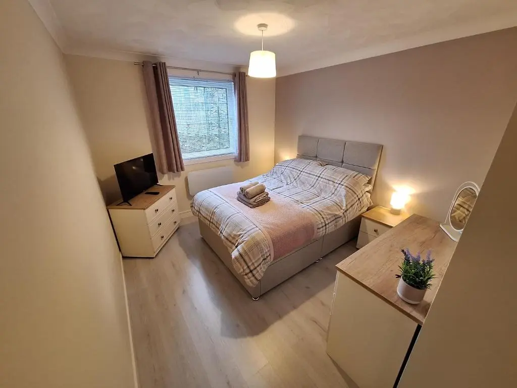 a small bedroom with a bed and a television at Modern Two Bed City Apartment!! in Inverness