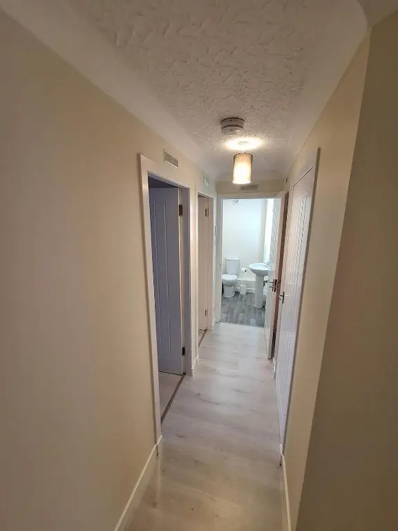 an empty hallway with a hallway leading to a room at Modern Two Bed City Apartment!! in Inverness