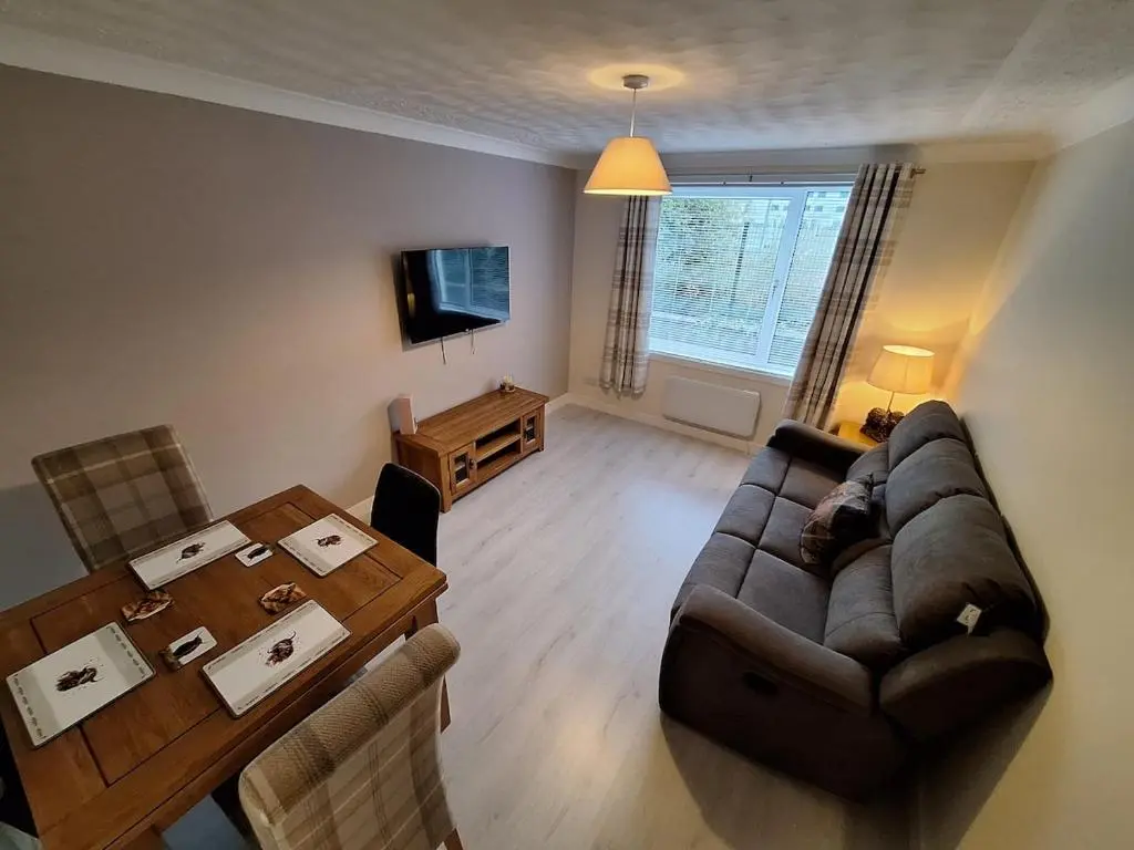 a living room with a couch and a table at Modern Two Bed City Apartment!! in Inverness