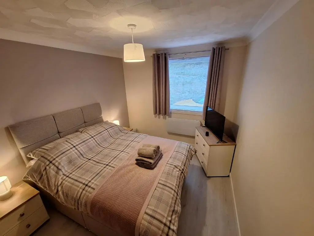 a bedroom with a bed and a television in it at Modern Two Bed City Apartment!! in Inverness