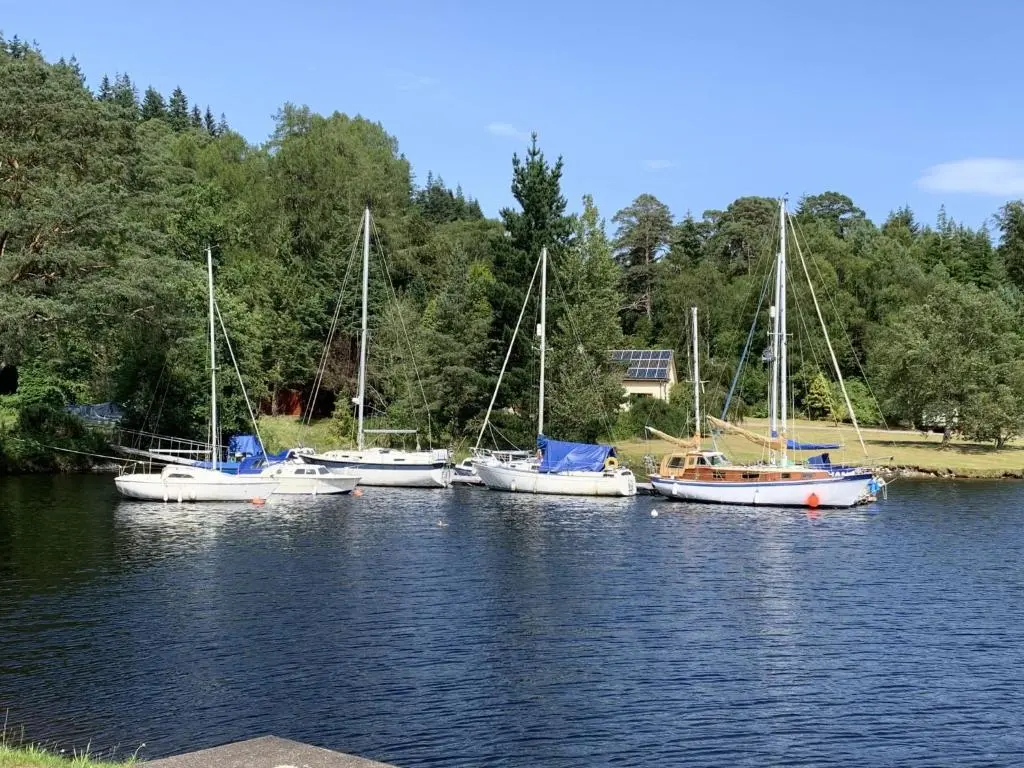 a group of boats sitting in the water at Chalet Pine Needle Lodge by Interhome in Spean Bridge