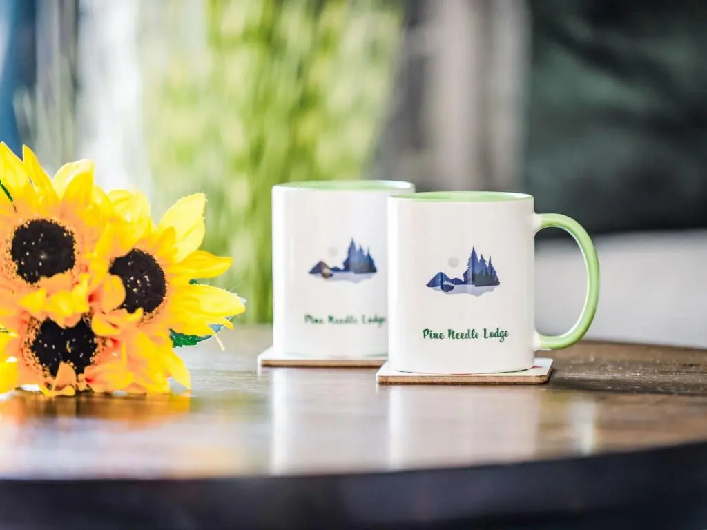 two coffee mugs sitting on a table with sunflowers at Chalet Pine Needle Lodge by Interhome in Spean Bridge