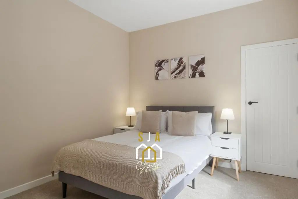 a bedroom with a bed with two lamps on it at Fraserburgh Residence - SJA Stays - Modern 3 Bed Apartment in Fraserburgh