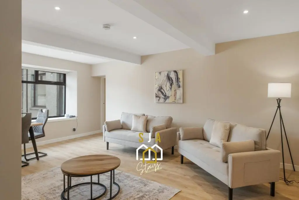 a living room with a couch and a table at Fraserburgh Residence - SJA Stays - Modern 3 Bed Apartment in Fraserburgh