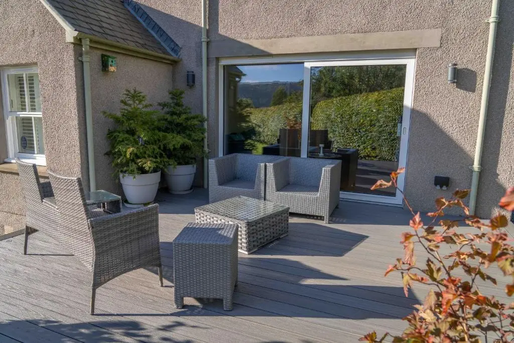 a patio with chairs and a couch and a table at Glen Tilt House in Bridge of Tilt