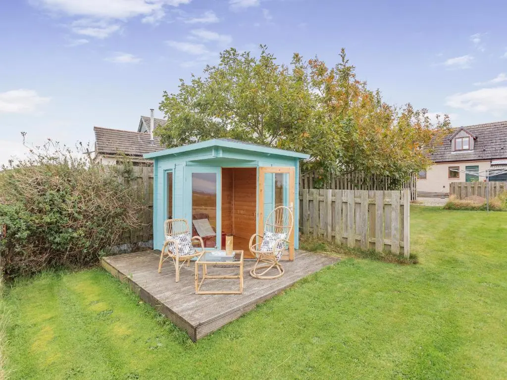 a gazebo with chairs and a table in a yard at East Cottage in Cawdor