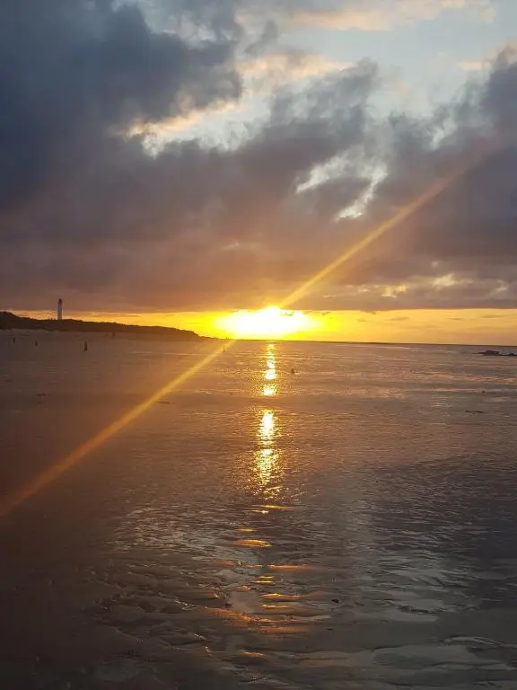 a sunset on the beach with the sun setting at Institution Road in Elgin
