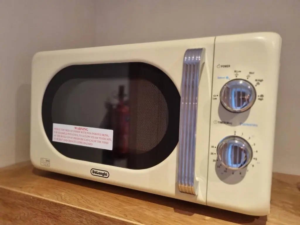 a white microwave sitting on top of a table at Village view apartment in Auldearn