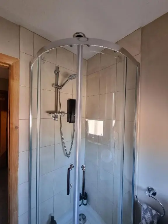 a shower with a glass door in a bathroom at Village view apartment in Auldearn