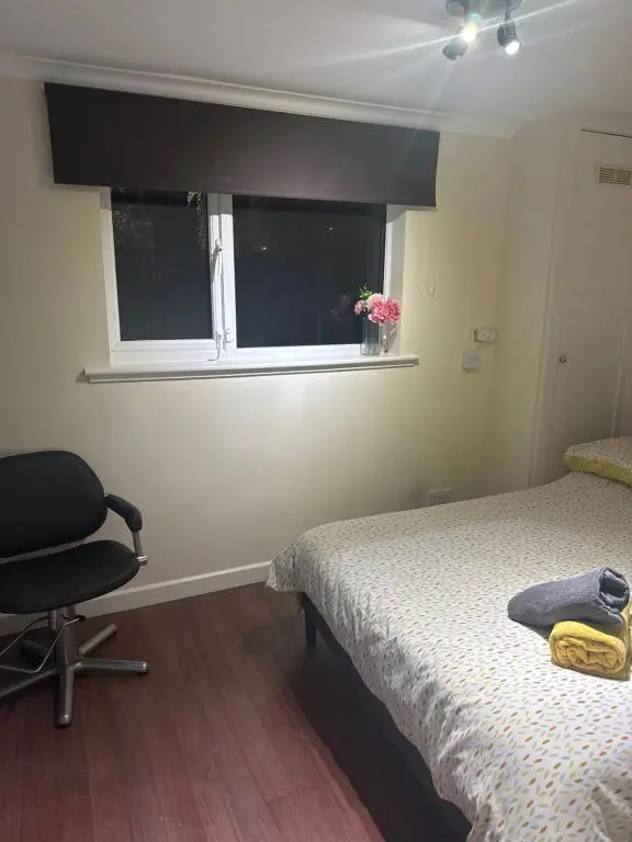 a bedroom with a bed and a chair and a window at Georges 47 king street Apartment in Inverness