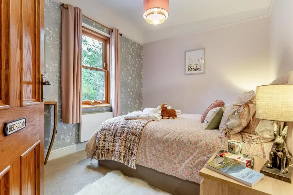 a bedroom with a bed with a dog laying on it at 2 Bed in Invergordon oc-c33073 in Invergordon